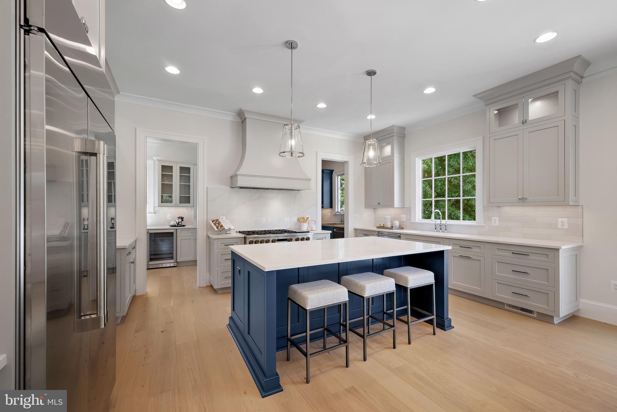 8628 Plymouth Road Alexandria, VA 22308 - Photo 3 of 50 a kitchen with stainless steel appliances kitchen island granite countertop a table chairs sink refrigerator and cabinets
