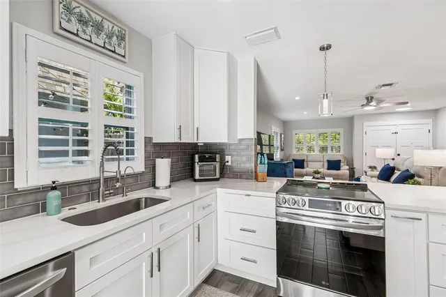 a kitchen with white cabinets stainless steel appliances and sink