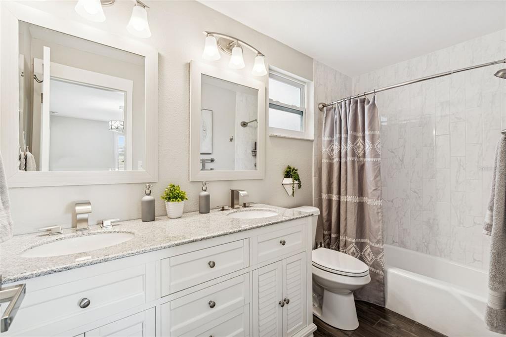 5809 Rio Drive New Port Richey, FL 34652 - Photo 32 of 61 a bathroom with a granite countertop toilet sink and a mirror