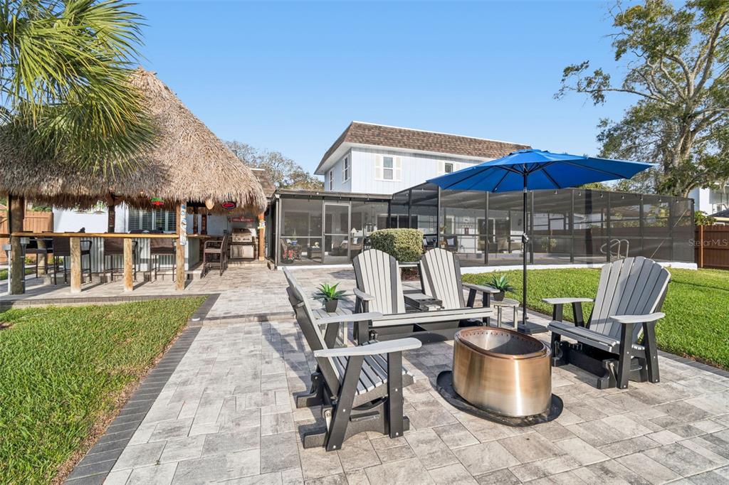 5809 Rio Drive New Port Richey, FL 34652 - Photo 42 of 61 a view of a patio with a dining table and chairs under an umbrella