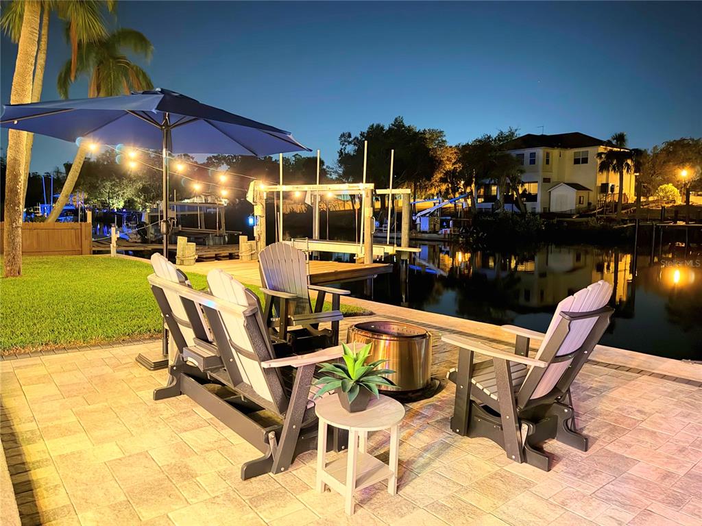 5809 Rio Drive New Port Richey, FL 34652 - Photo 61 of 61 a view of a patio with a dining table and chairs under an umbrella
