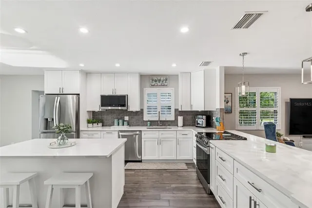 a kitchen with stainless steel appliances granite countertop a stove a sink and a granite counter tops