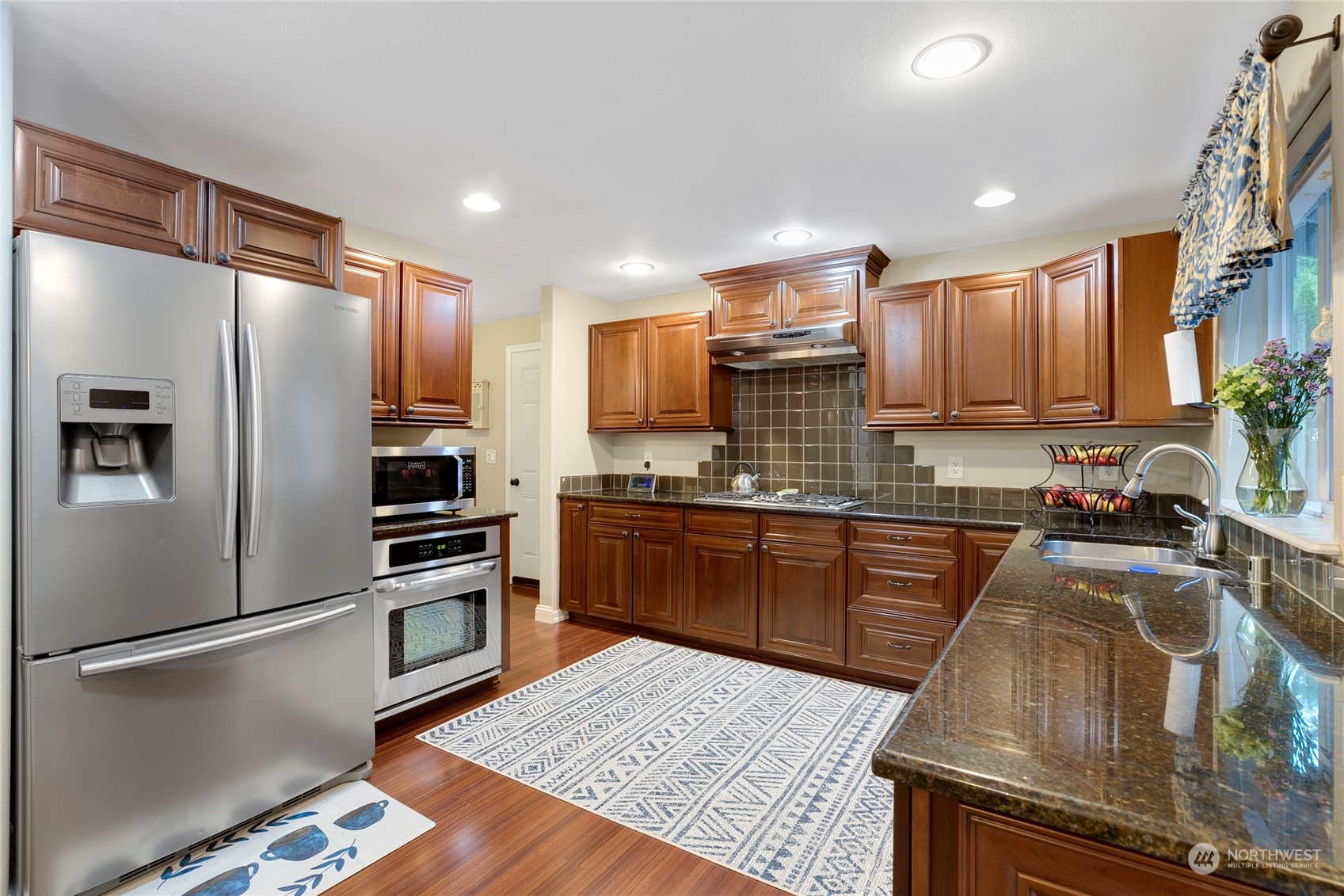 1124 Summit Lake Shore Road Northwest Olympia, WA 98502 - Photo 11 of 40 a kitchen with granite countertop stainless steel appliances and wooden cabinets