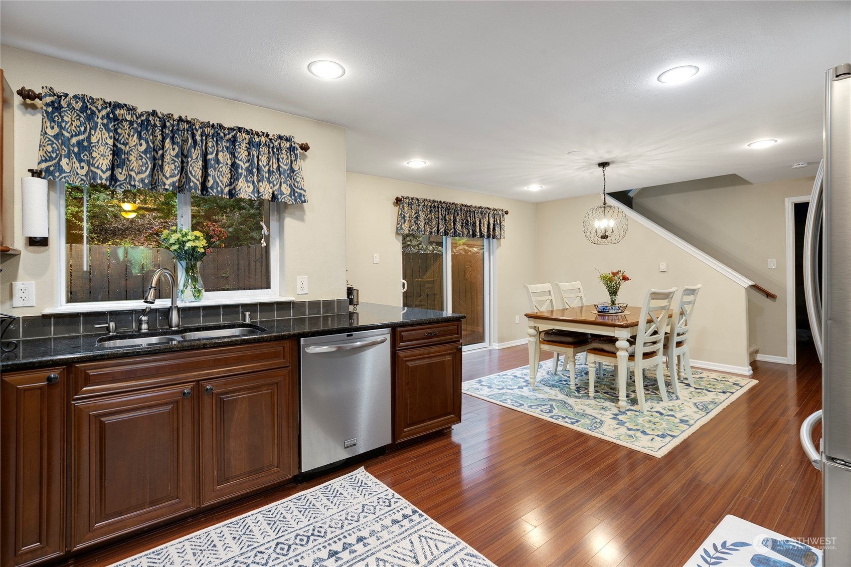 1124 Summit Lake Shore Road Northwest Olympia, WA 98502 - Photo 12 of 40 a dining hall with granite countertop a stove a sink a dining table and chairs with wooden floor