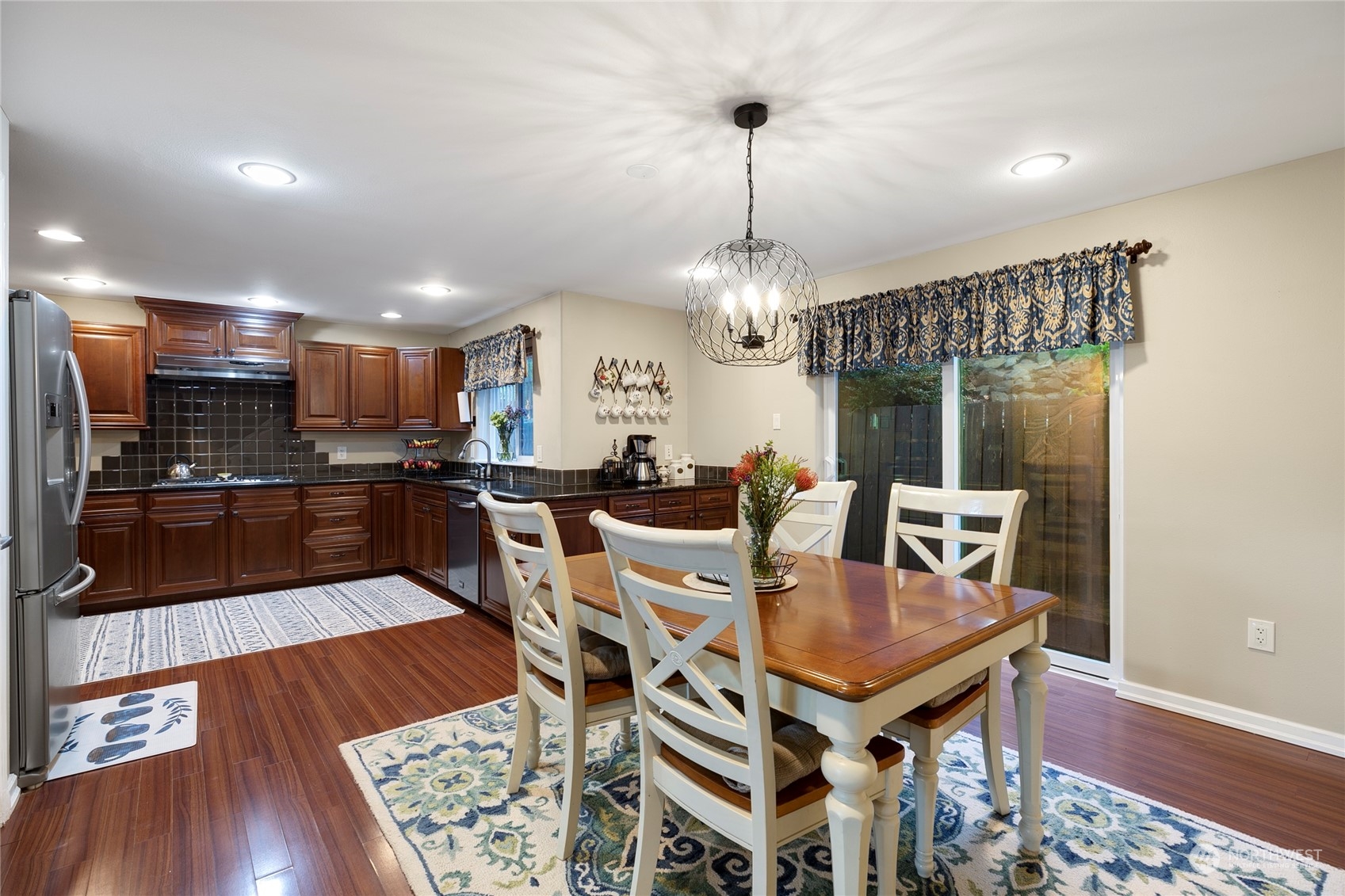 1124 Summit Lake Shore Road Northwest Olympia, WA 98502 - Photo 13 of 40 a kitchen with stainless steel appliances granite countertop a stove a kitchen island a dining table and chairs with wooden floor