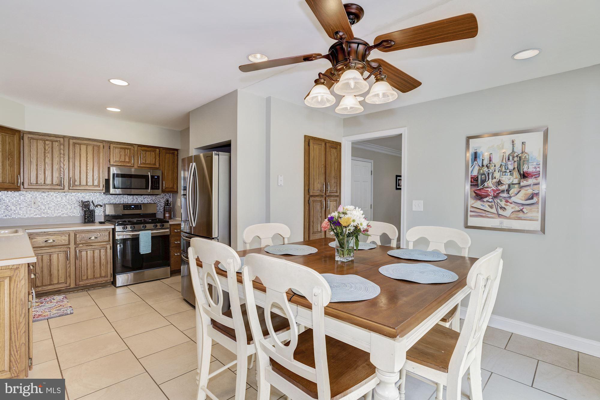 6 Mariner Drive Sewell, NJ 08080 - Photo 13 of 32 a kitchen with a dining table cabinets stainless steel appliances and a chandelier