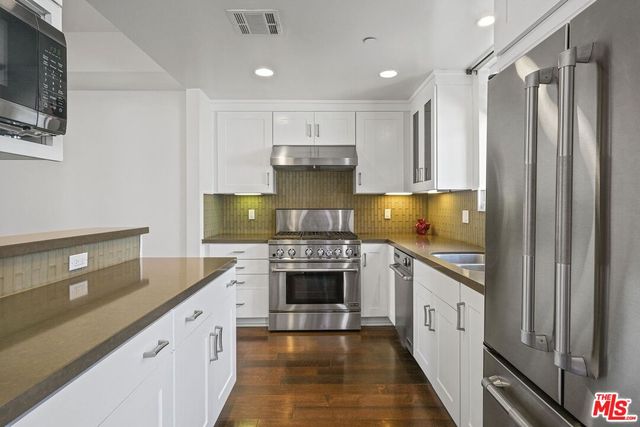 a kitchen with granite countertop a sink stove and cabinets