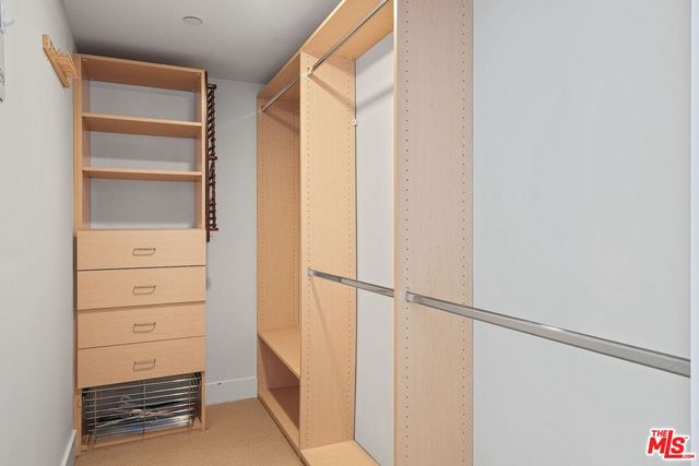 a view of walk in closet with empty racks