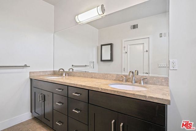 a bathroom with a granite countertop sink double and mirror