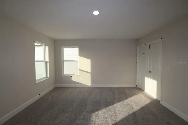 an empty room with windows and cabinet