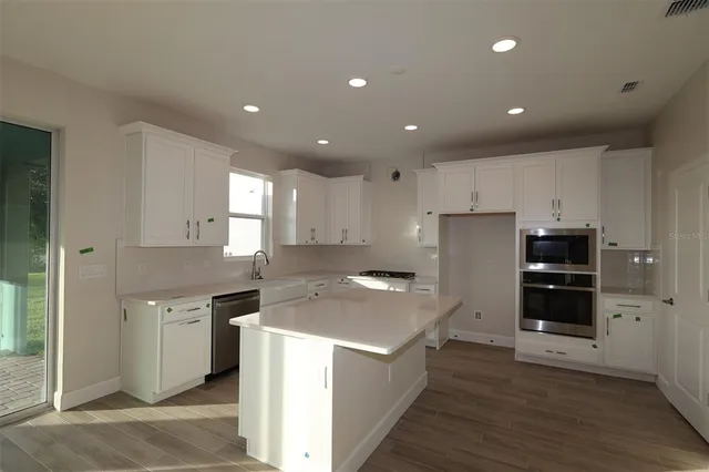 a kitchen with kitchen island a sink stainless steel appliances and cabinets