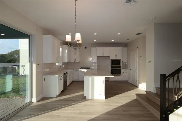 a open kitchen with a sink and refrigerator