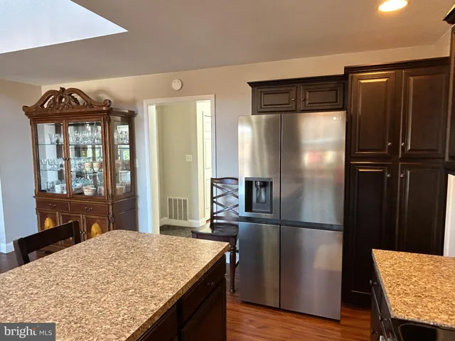 a kitchen with a refrigerator and wooden cabinets