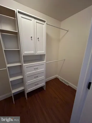 a view of walk in closet with empty racks