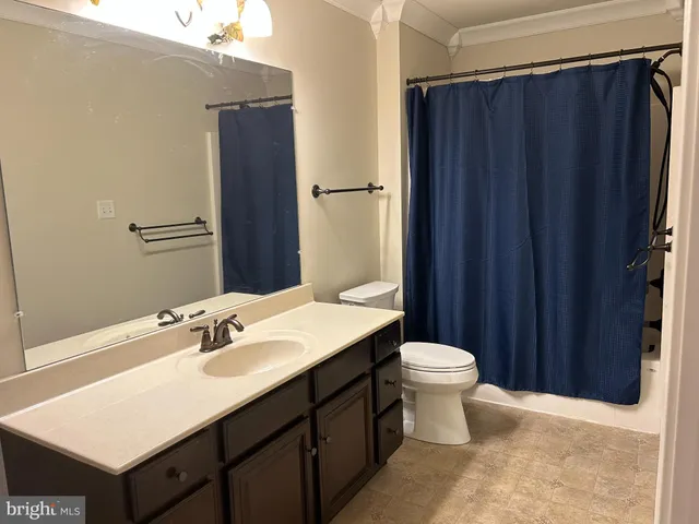 a bathroom with a sink vanity mirror and toilet