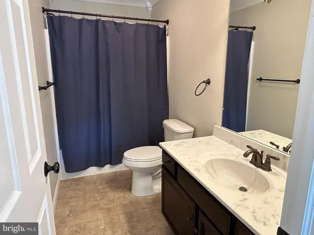a bathroom with a granite countertop sink toilet and vanity