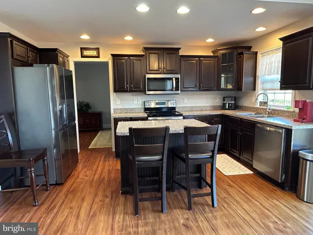 a kitchen with stainless steel appliances wooden floors and wooden cabinets