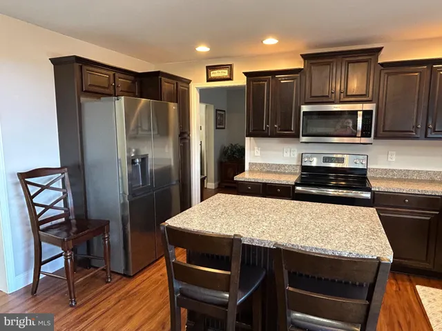 a kitchen with granite countertop a refrigerator stove top oven and sink