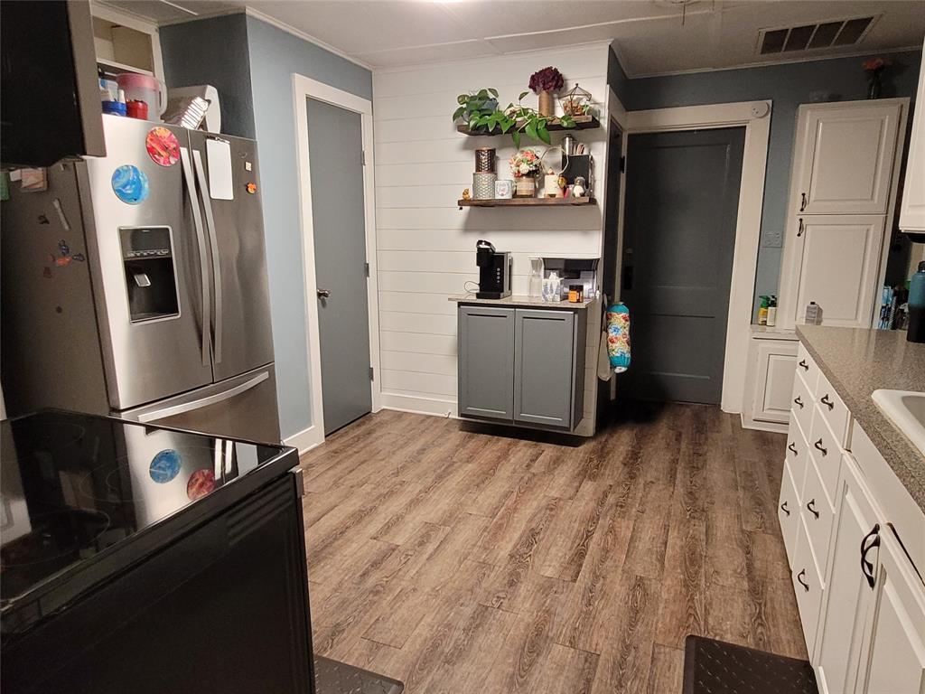 117 West 3rd Street, Unit A Keene, TX 76059 - Photo 11 of 14 a kitchen with stainless steel appliances a refrigerator and a stove