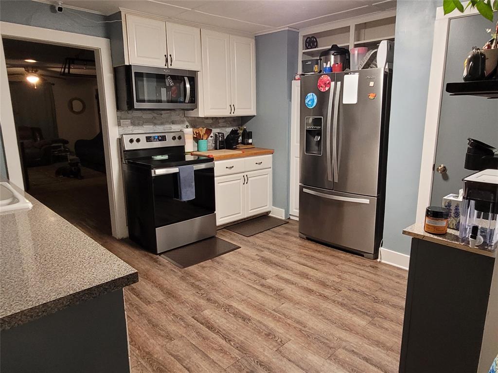 117 West 3rd Street, Unit A Keene, TX 76059 - Photo 9 of 14 a kitchen with stainless steel appliances granite countertop a refrigerator stove and sink