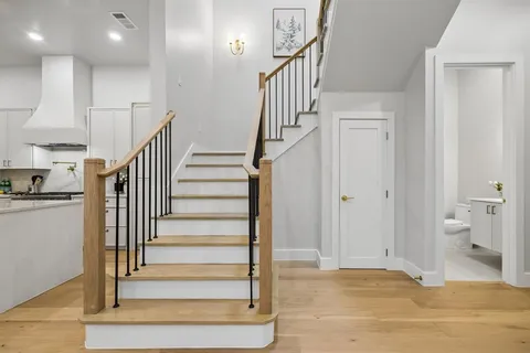 a view of entryway and hall with wooden floor