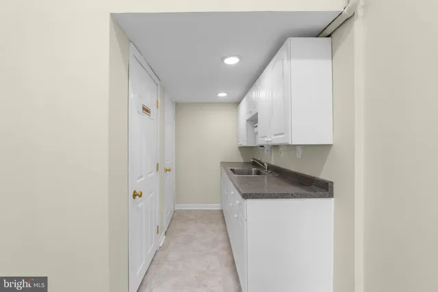 a kitchen with granite countertop a sink and a refrigerator
