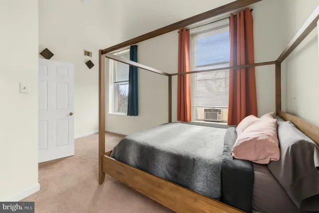 a bedroom with a bed next to a window
