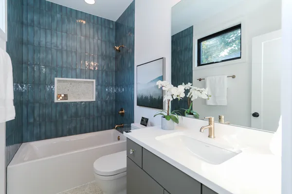 a bathroom with a sink a toilet and shower