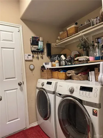 a view of washer and dryer with kitchen in the background