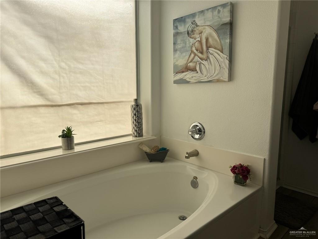3407 San Angelo Street Mission, TX 78572 - Photo 26 of 40 a bathroom with a bathtub and a shower