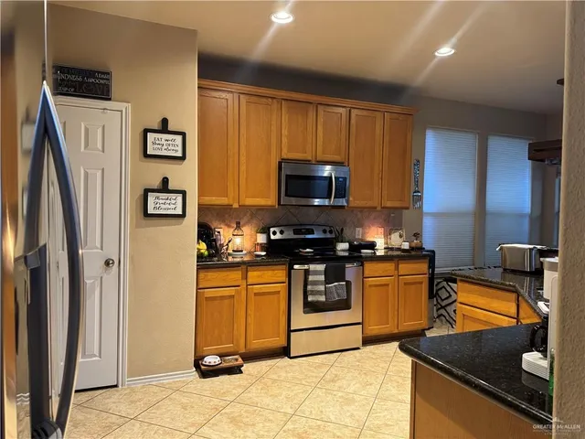 a kitchen with stainless steel appliances granite countertop a refrigerator stove and sink