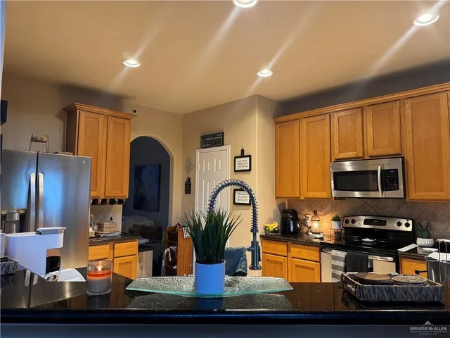 a kitchen with wooden cabinets and stainless steel appliances