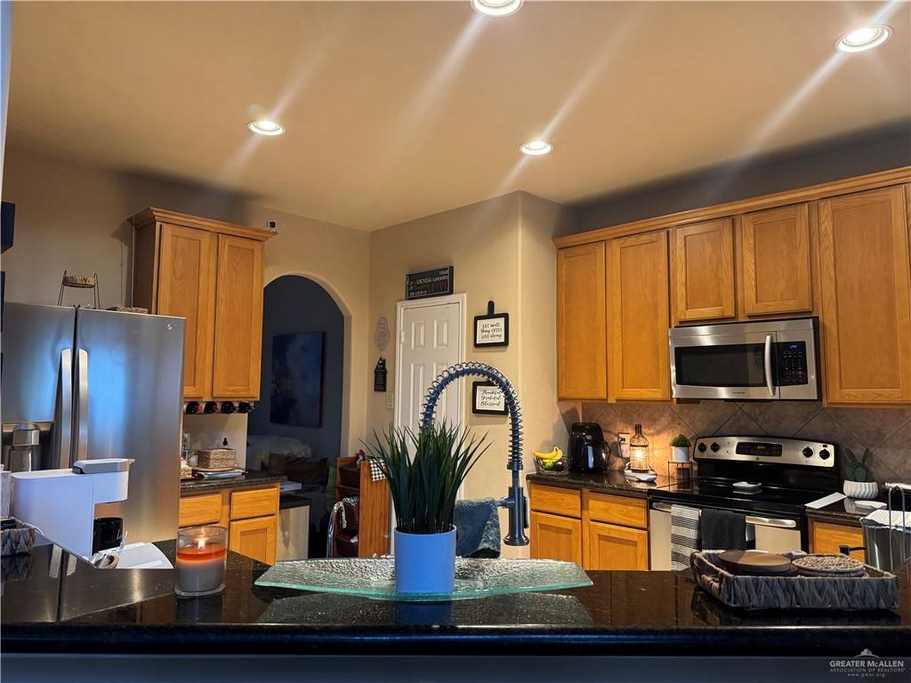 3407 San Angelo Street Mission, TX 78572 - Photo 7 of 40 a kitchen with wooden cabinets and stainless steel appliances