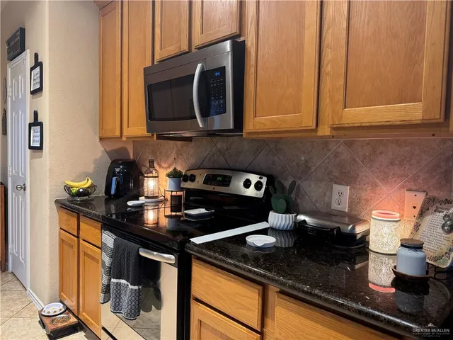 a kitchen with stainless steel appliances granite countertop a sink stove and microwave