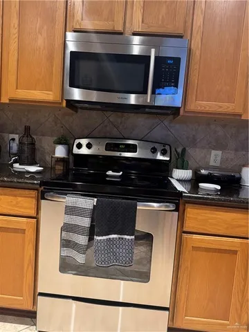 a kitchen with stainless steel appliances granite countertop a stove and a microwave