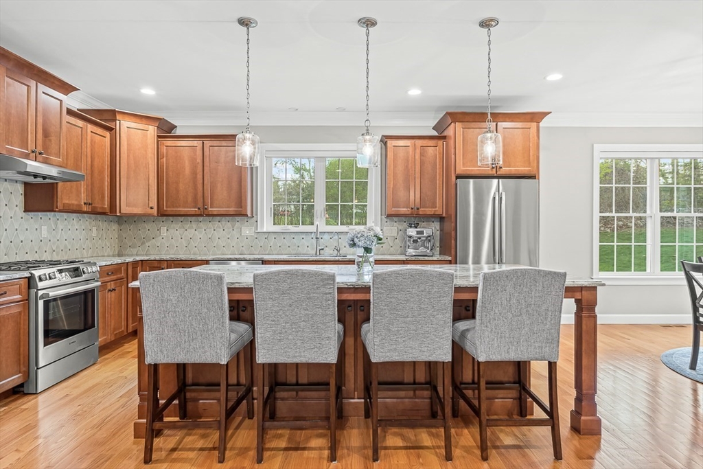 15 Maryvale Road Burlington, MA 01803 - Photo 11 of 42 a kitchen with stainless steel appliances granite countertop a stove a refrigerator a kitchen island a table and chairs