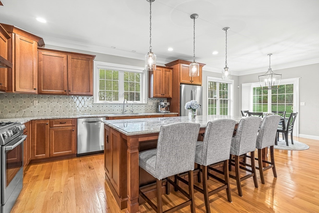 15 Maryvale Road Burlington, MA 01803 - Photo 12 of 42 a open kitchen with granite countertop a stove a sink a dining table and chairs