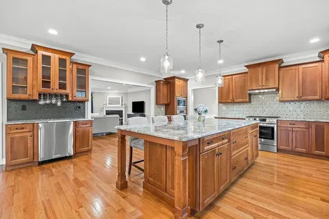 a kitchen with stainless steel appliances granite countertop a sink a stove top oven a counter space and cabinets