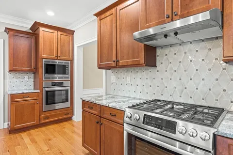 a kitchen with granite countertop a stove and a microwave