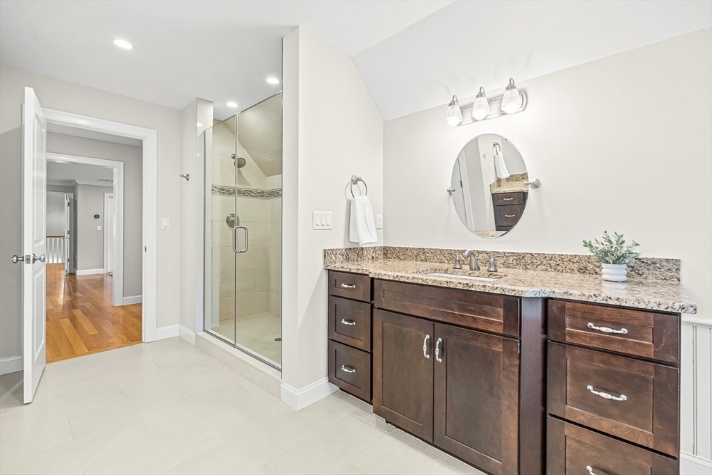 15 Maryvale Road Burlington, MA 01803 - Photo 27 of 42 a bathroom with a granite countertop sink a mirror and a shower