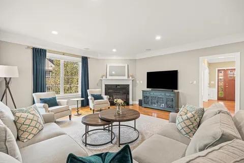 a living room with furniture a flat screen tv and a large window