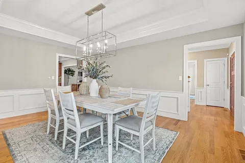 a view of a dining room with furniture wooden floor and chandelier