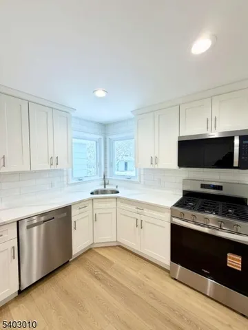 a kitchen with granite countertop a stove top oven sink and cabinets