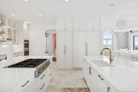 a bedroom with a bed a large window and wooden floor