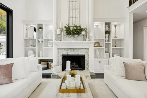 a living room with furniture a fireplace and a chandelier