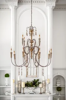 a bedroom with a large bed a chandelier and windows