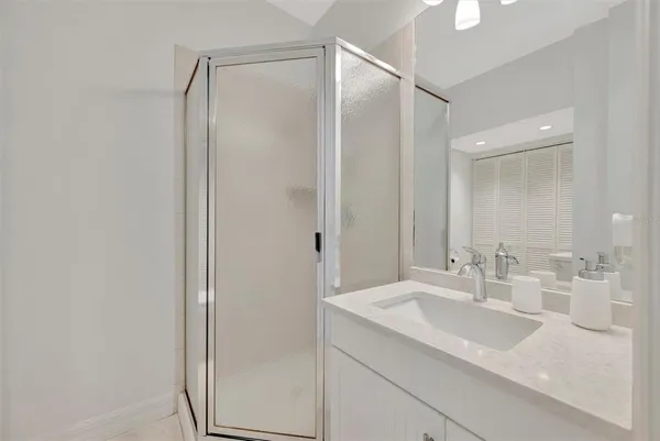 a spacious bathroom with a granite countertop sink a mirror and a shower