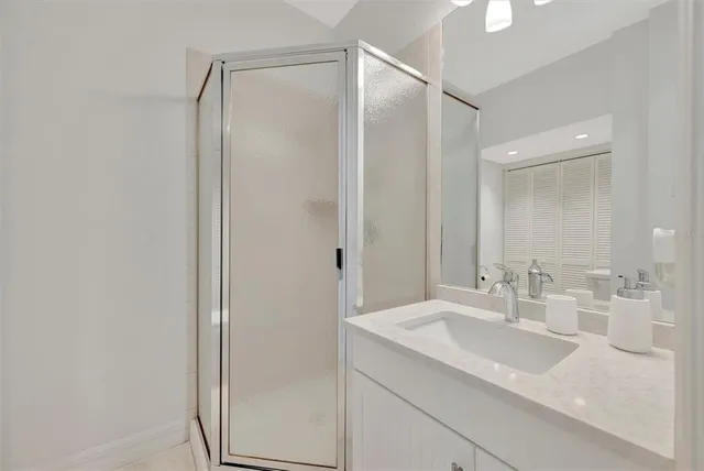 a spacious bathroom with a granite countertop sink a mirror and a shower
