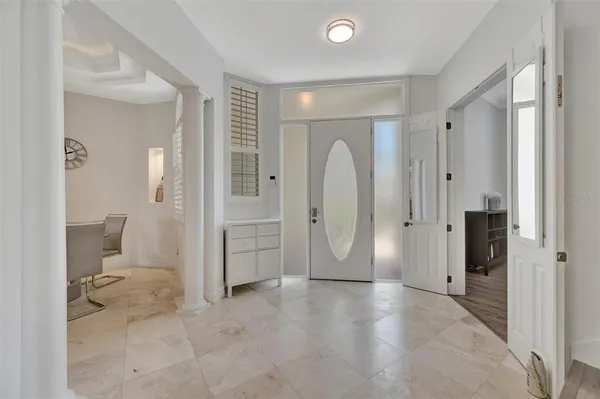 a dining room with wooden floor a chandelier a wooden table and chairs