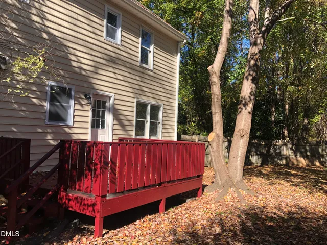 a view of a backyard with a large tree and wooden fence